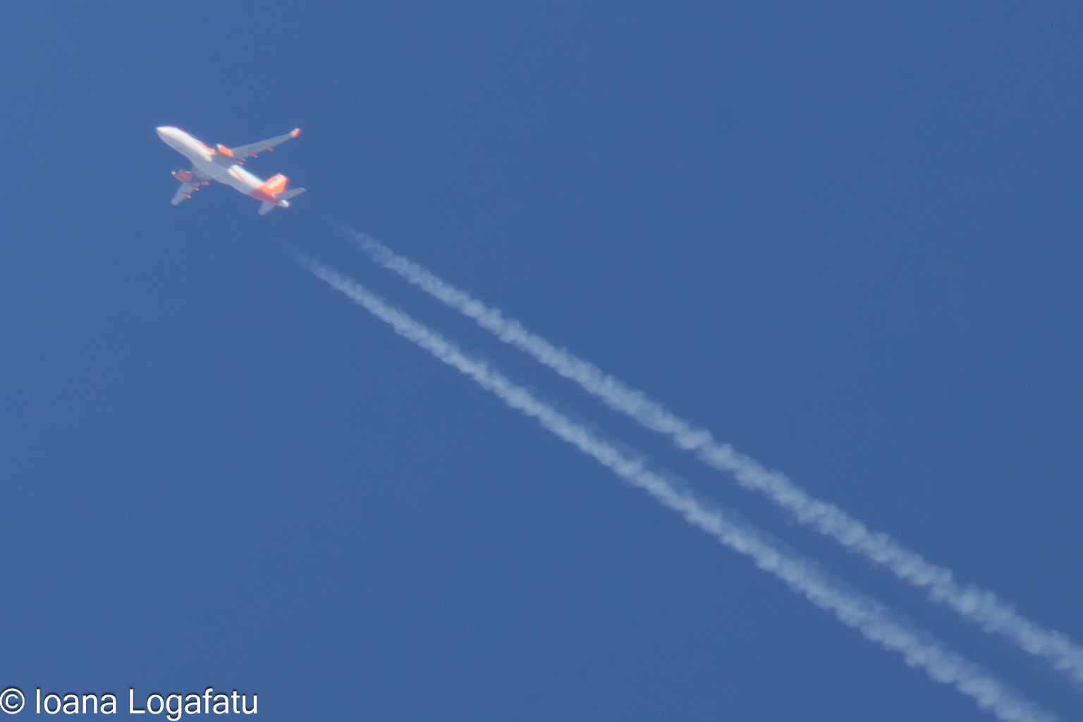 Airplane soaring high above a clear blue sky